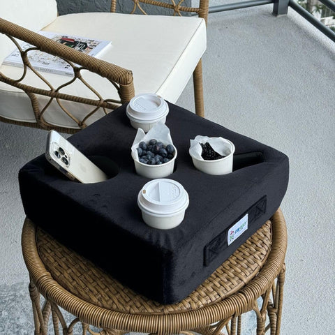 Cup Cozy Pillow placed on a couch keeping drinks and remotes organized