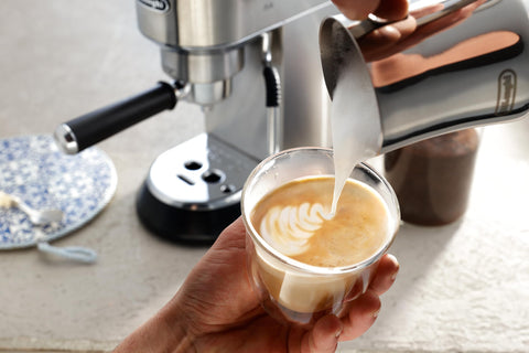 De'Longhi pitcher in use pouring milk into cup for smooth foam and control