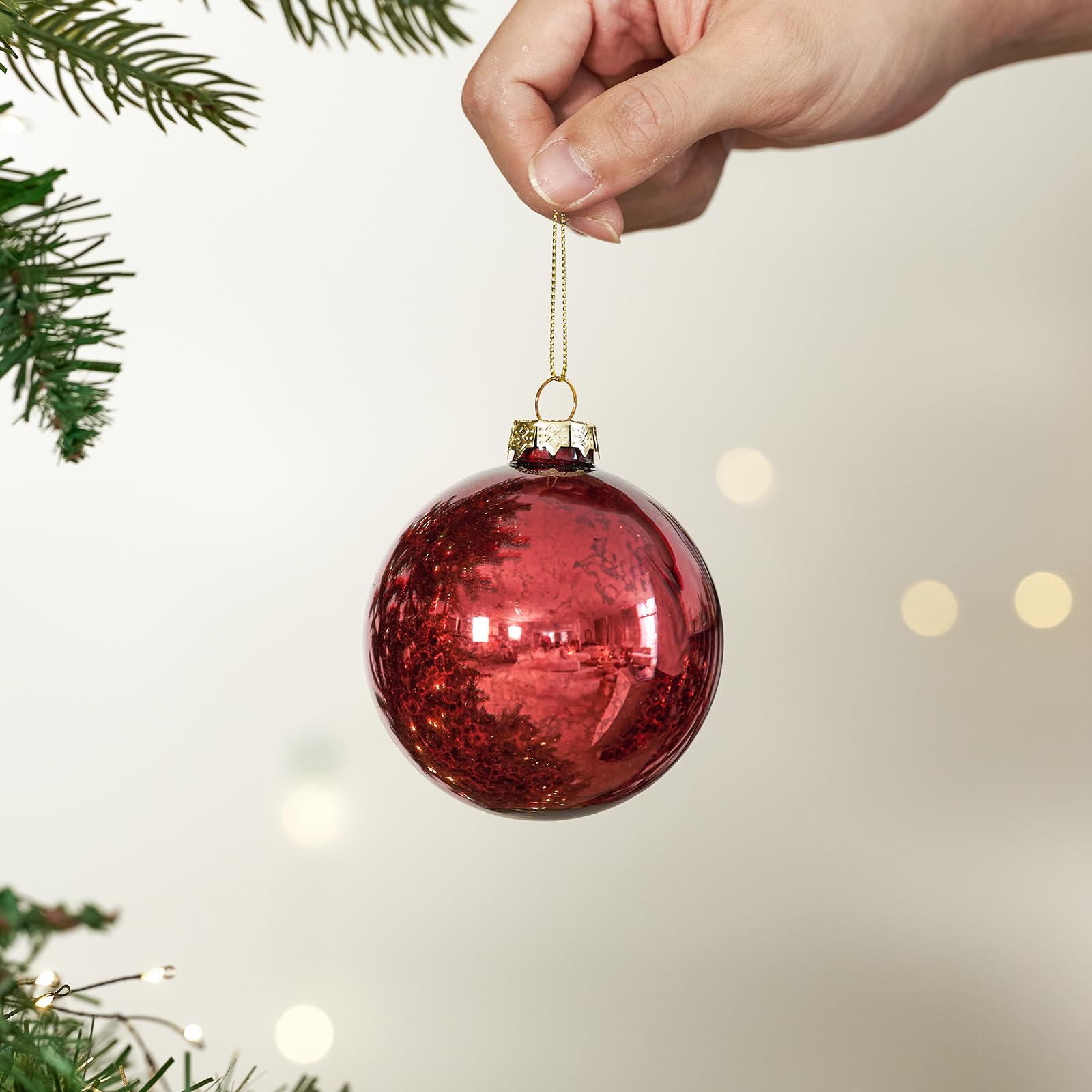 DN DECONATION clear bowl centerpiece filled with red mercury ornaments creating festive table ambience