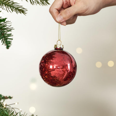 DN DECONATION clear bowl centerpiece filled with red mercury ornaments creating festive table ambience