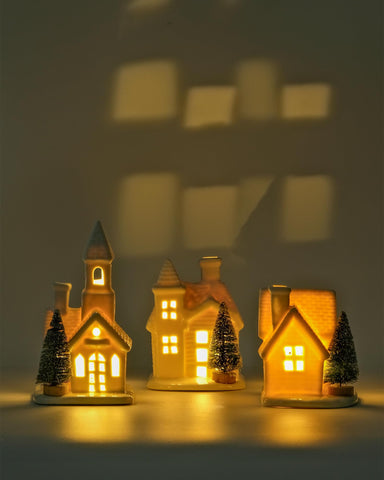 DN DECONATION front view of three white ceramic houses, adds cozy holiday glow