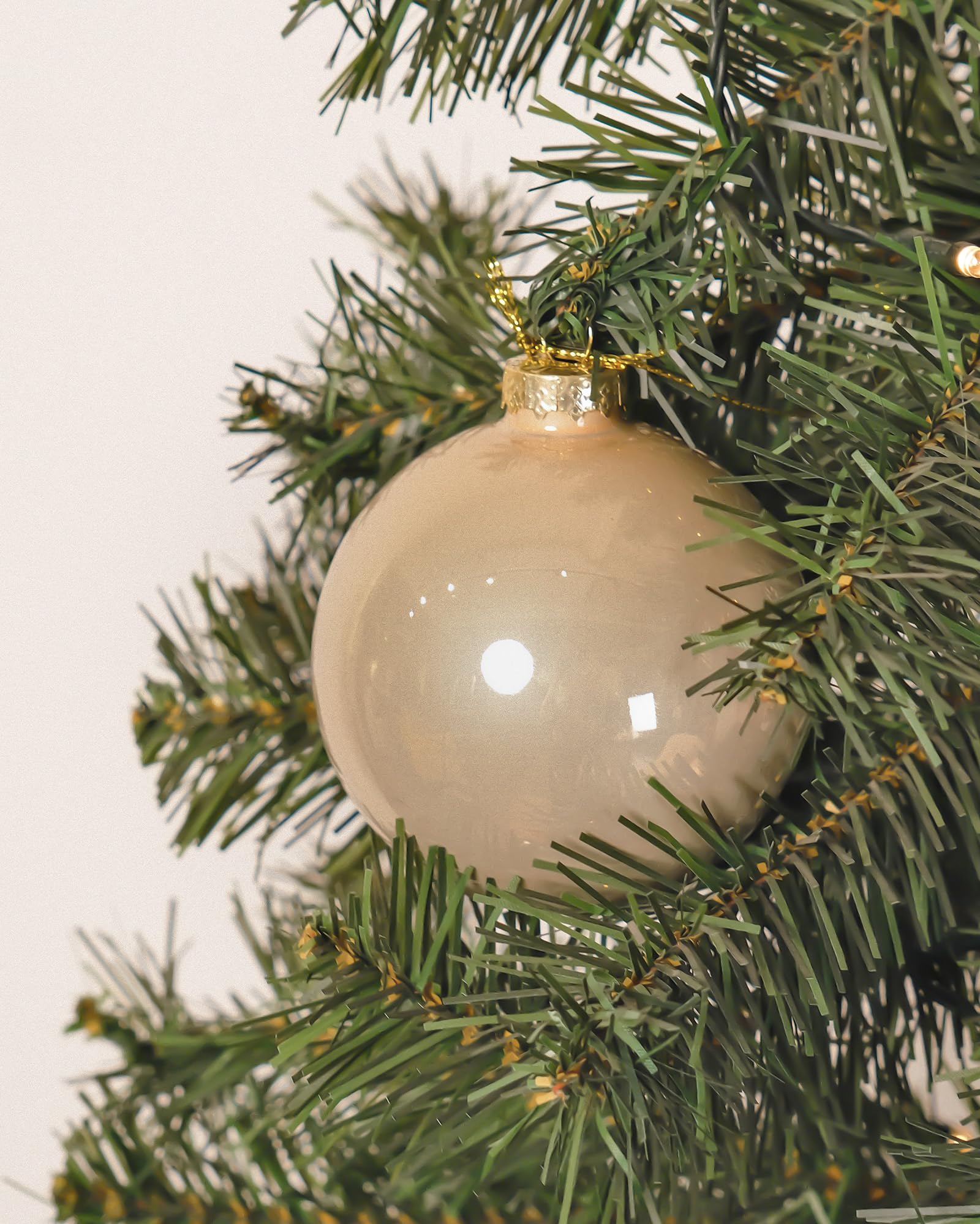 DN DECONATION ornaments hanging on a Christmas tree adding elegant champagne tone and depth