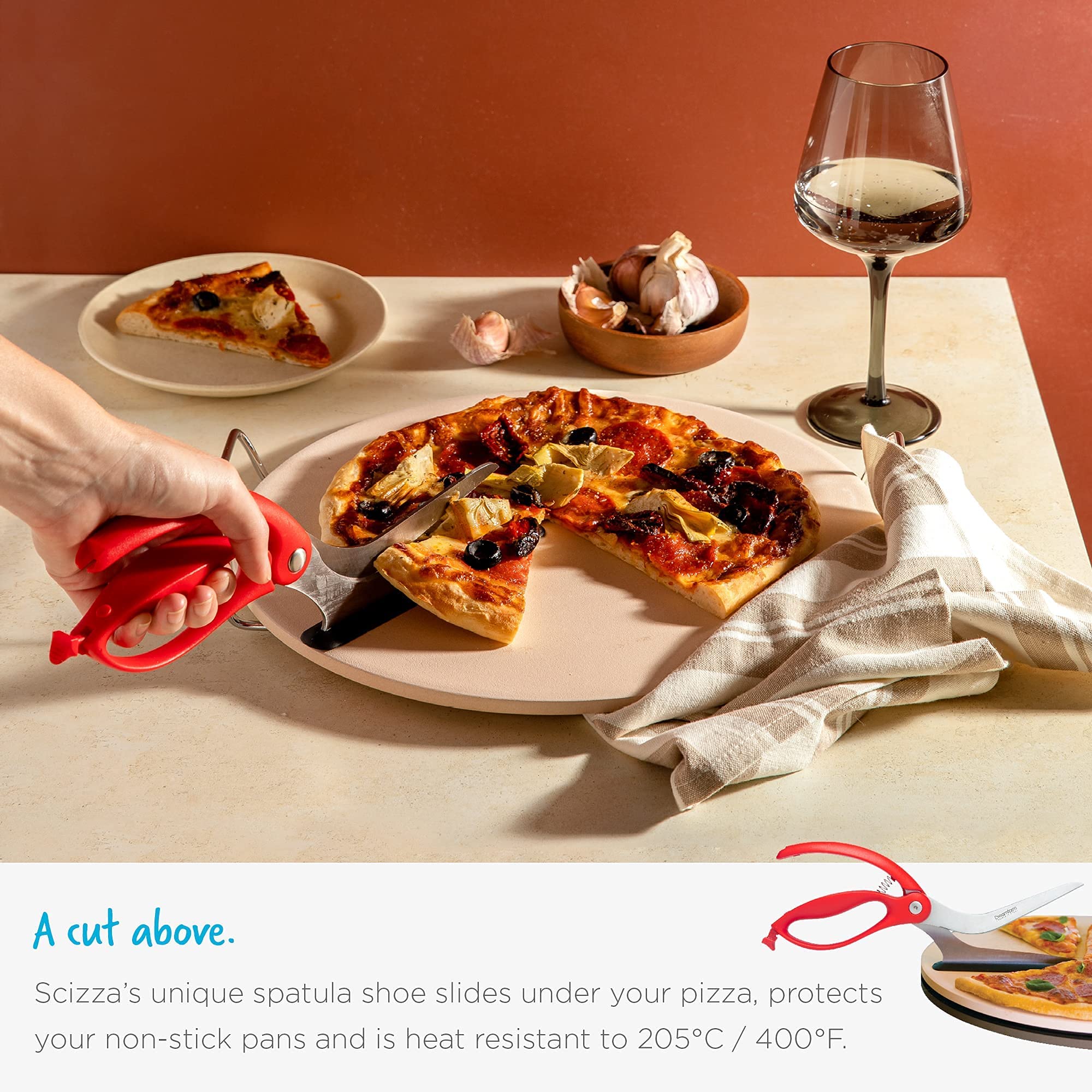 Dreamfarm Scizza beside utensils showing scale and compact design for easy storage