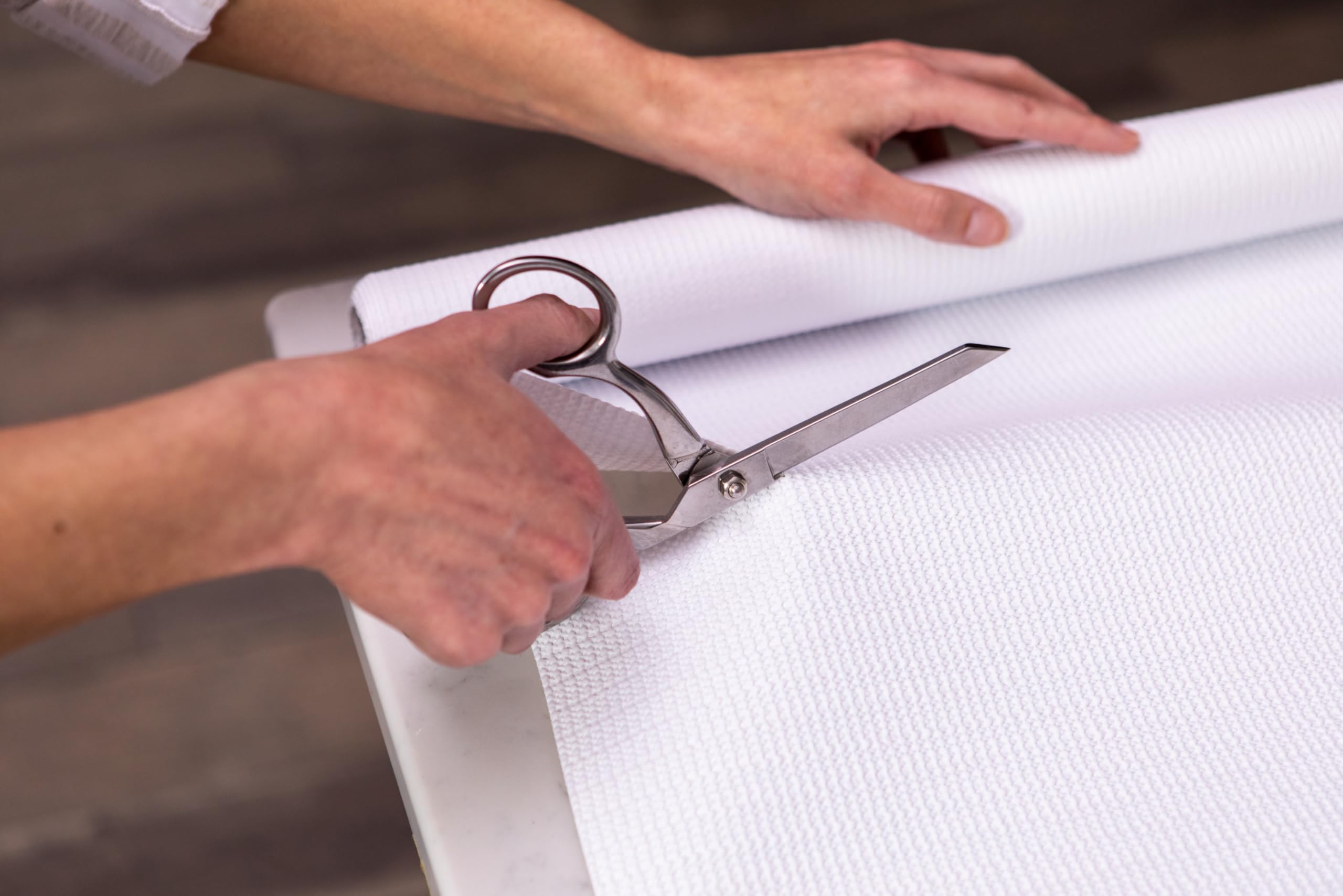 Duck EasyLiner being cut with scissors to fit a cabinet shelf for fast custom installation