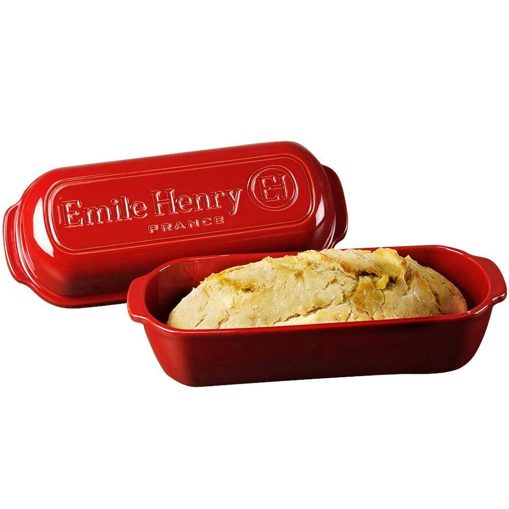 Emile Henry loaf baker held by hands for scale, demonstrating compact storage and handling