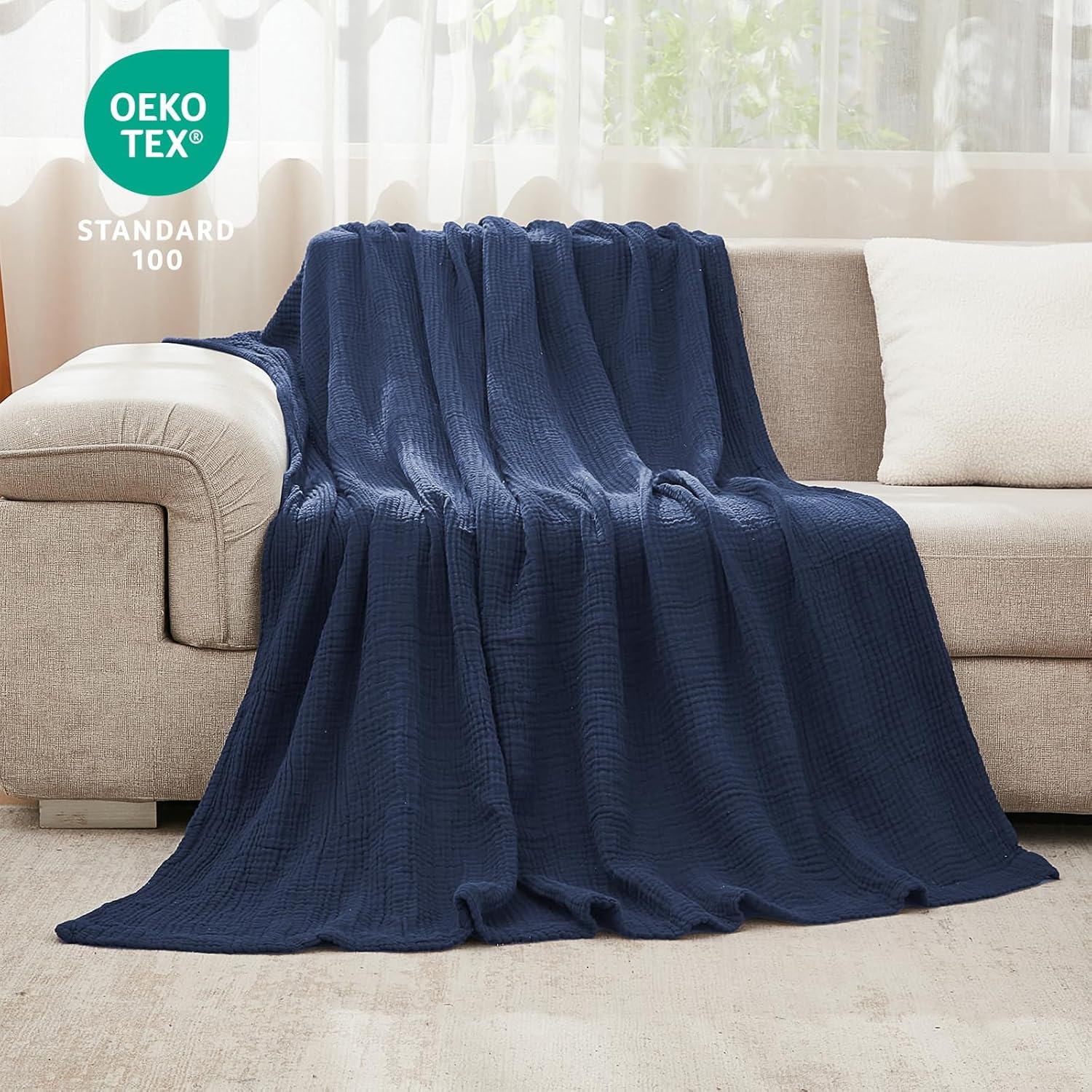 EMME navy throw draped on couch in living room adding breathable comfort and style