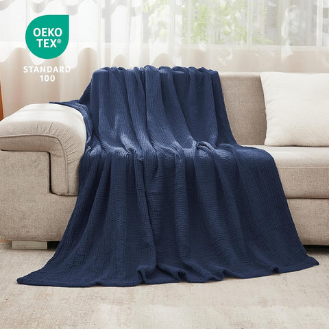 EMME navy throw draped on couch in living room adding breathable comfort and style