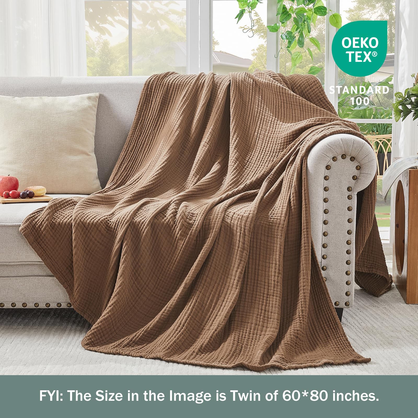 EMME blanket draped over sofa creating warm inviting living room atmosphere