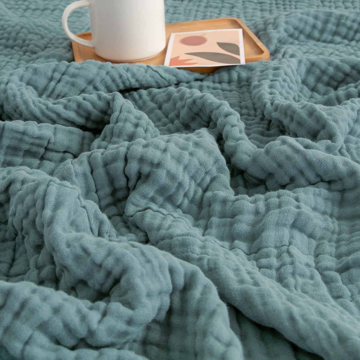 EMME front view of teal throw showing size and color benefits