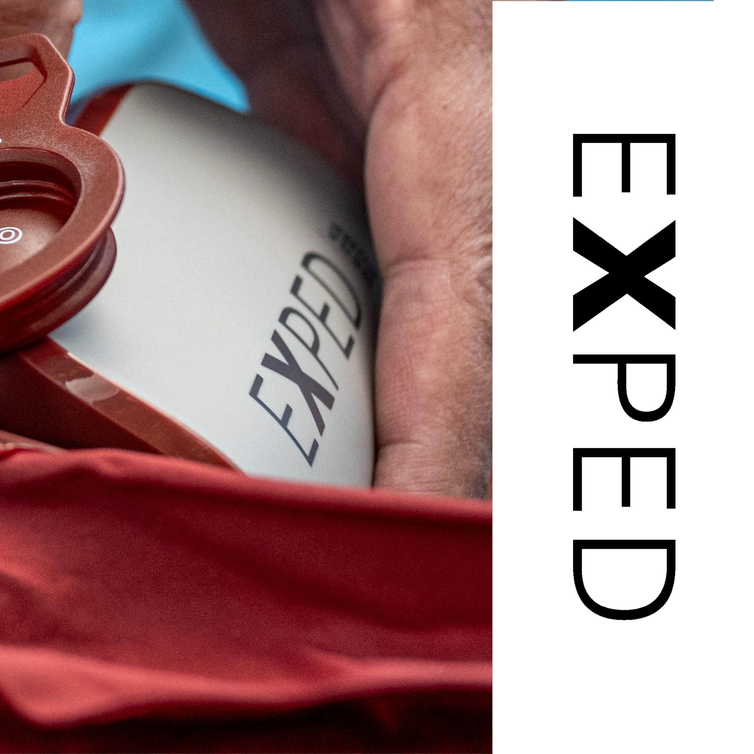 Exped Mega Pump next to a hand for scale, emphasizing portable packability