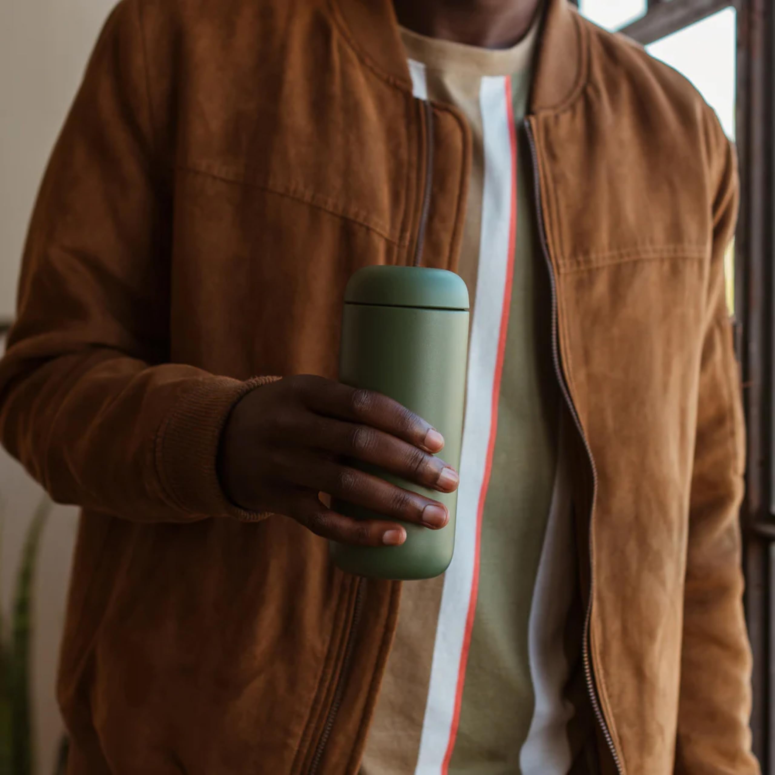 Fellow Carter Move next to smartphone showing 16 oz size and portability