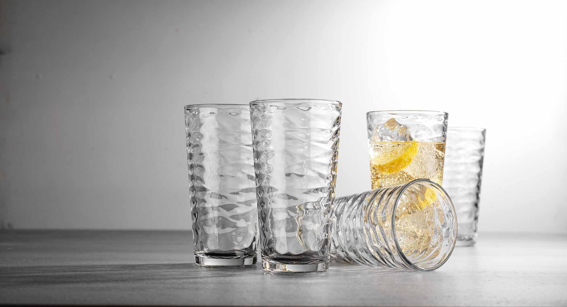 Glaver's hand holding a tall glass to show scale and comfortable everyday handling