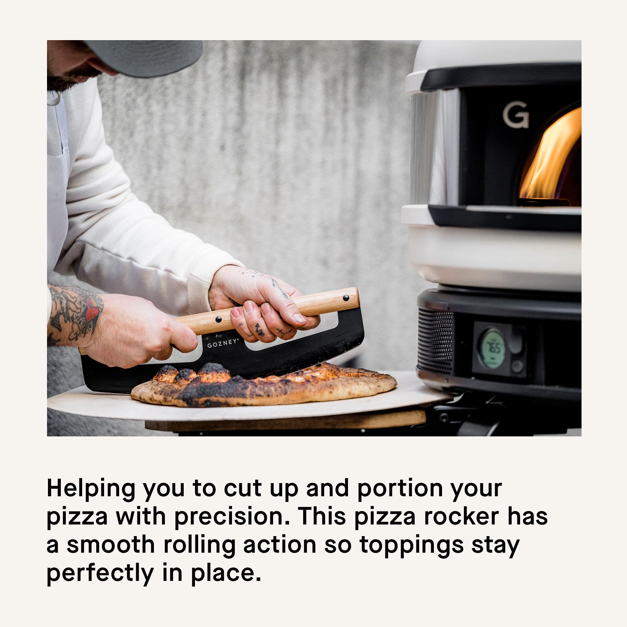Gozney rocker slicing a pizza in one sweep keeping toppings intact