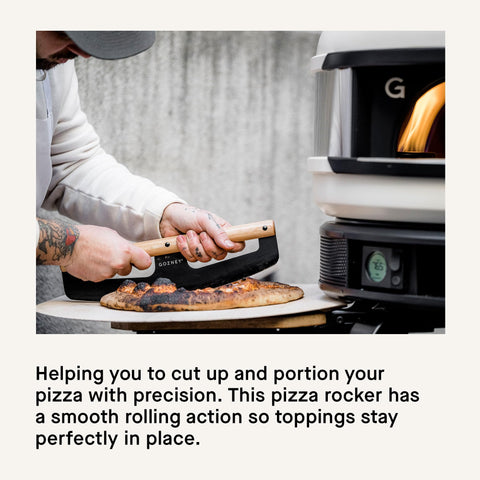 Gozney rocker slicing a pizza in one sweep keeping toppings intact