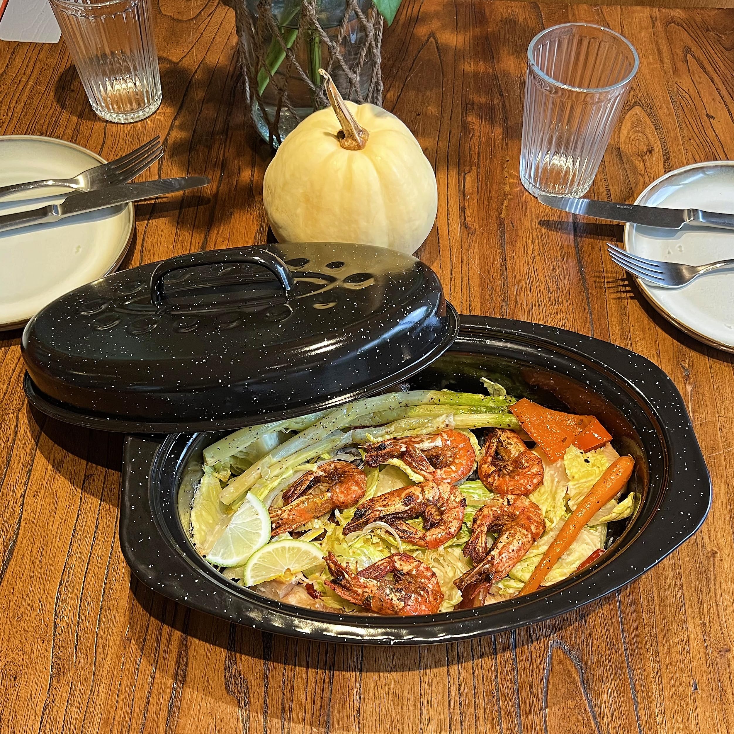 Granite bowl roaster on dining table styled with side dishes for elegant family presentation