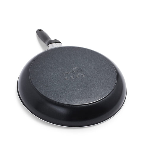 GreenPan Rio stock pot with stainless-steel steamer next to measuring cup showing capacity scale