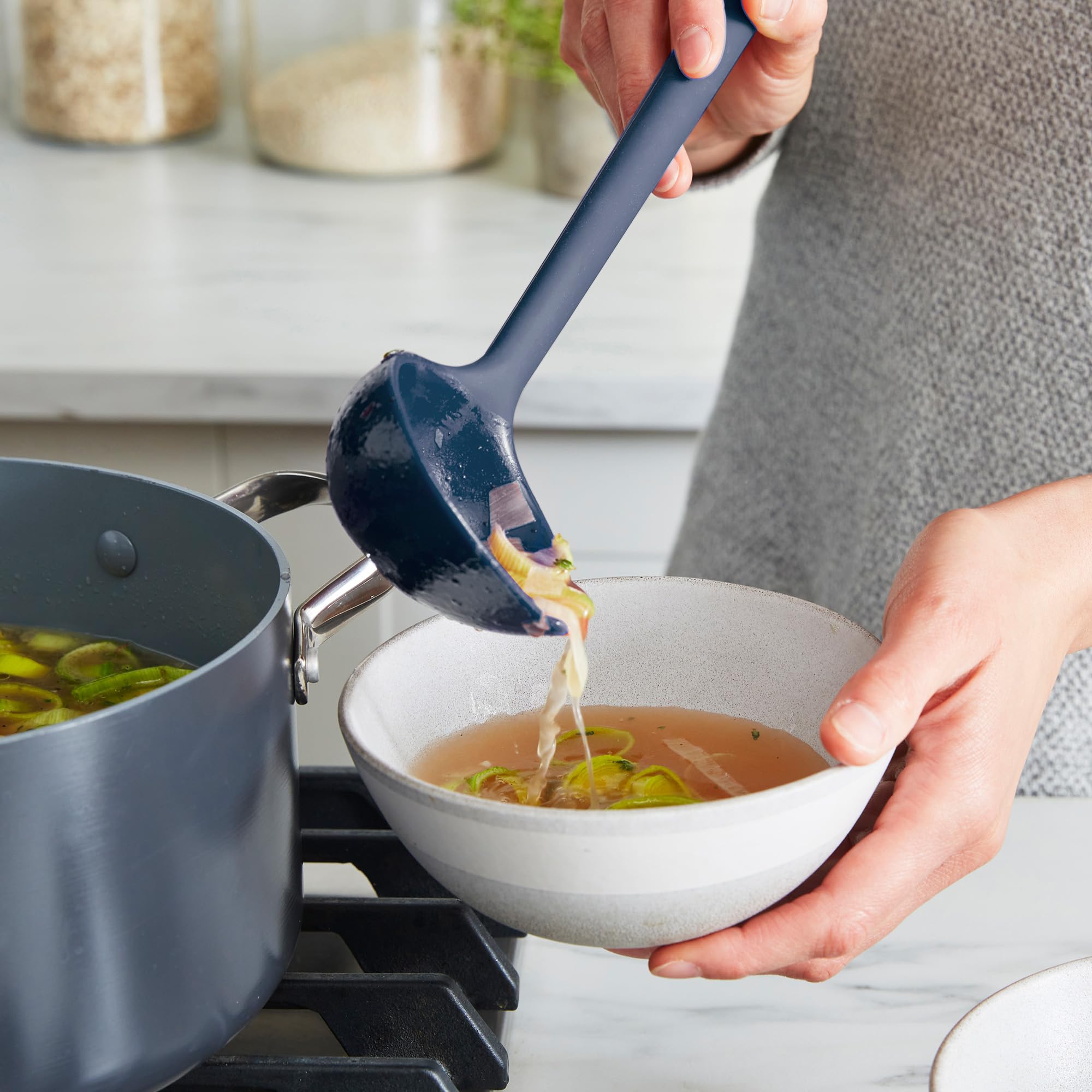 GreenPan flexible tool edges bending into pan corner, demonstrating reach and cleaning benefit