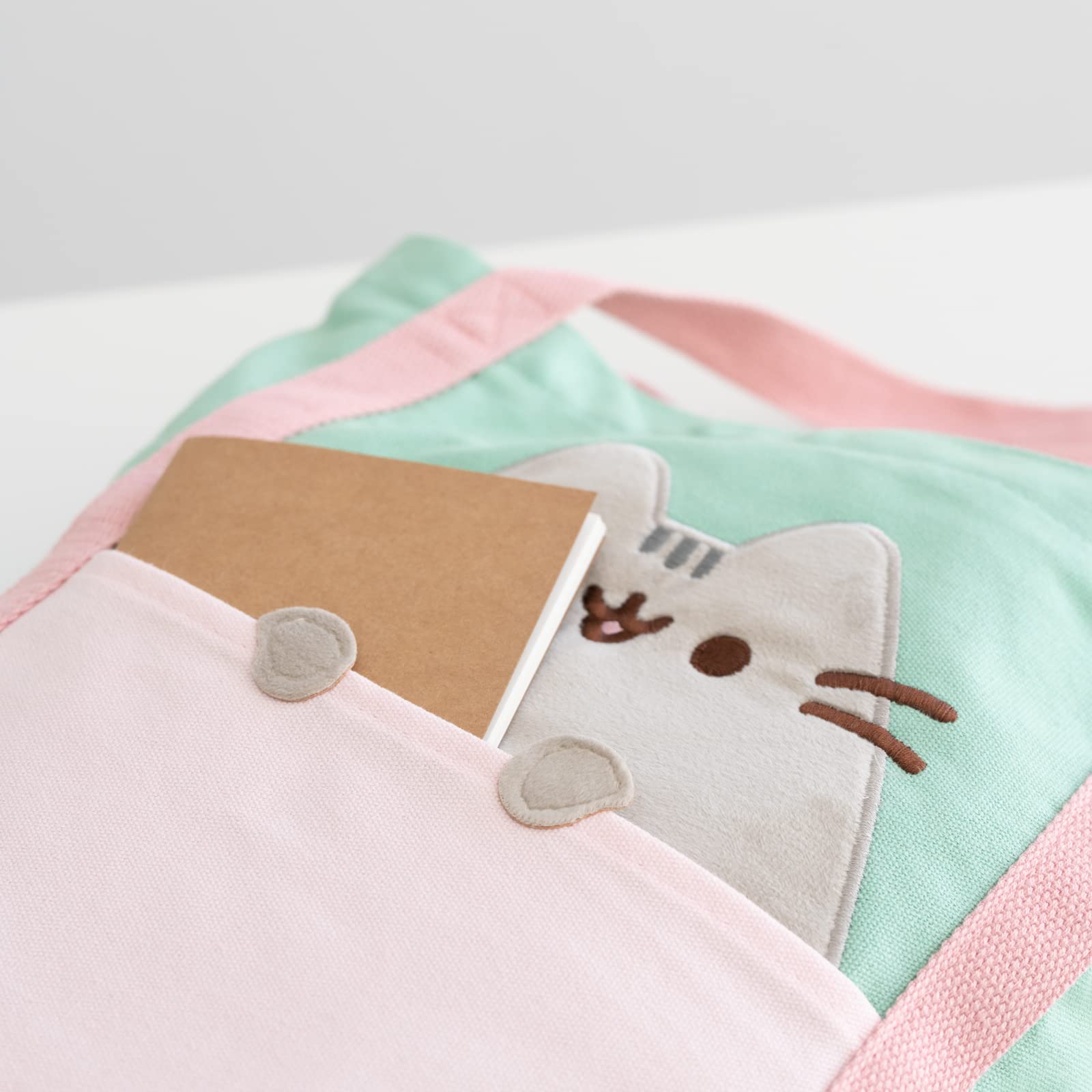 Grupo Erik Pusheen tote next to books to show capacity for textbooks