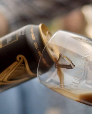 Guinness scale comparison next to bottle demonstrates true 20oz capacity