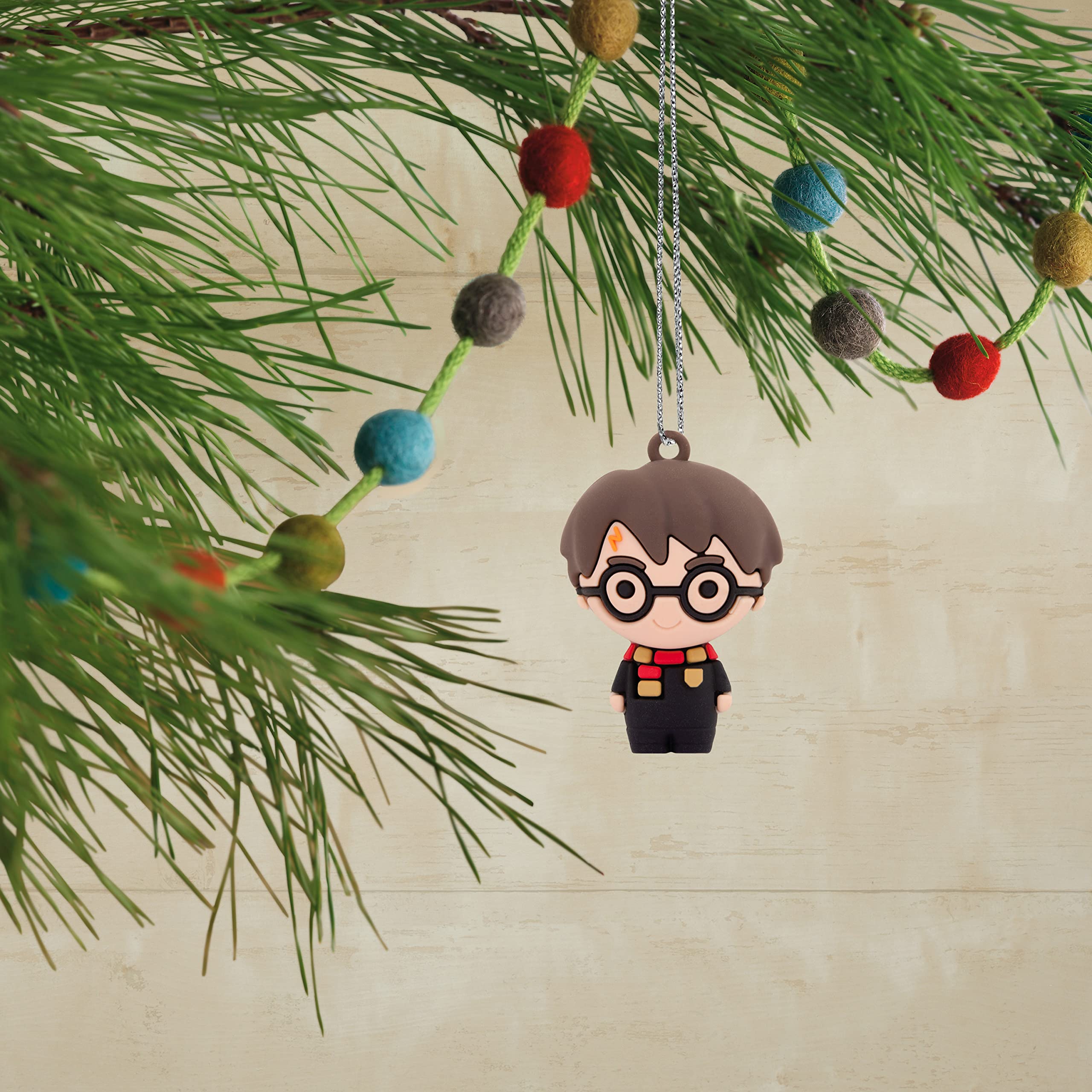Hallmark child hanging an ornament on tree illustrating safe, kid-friendly fun