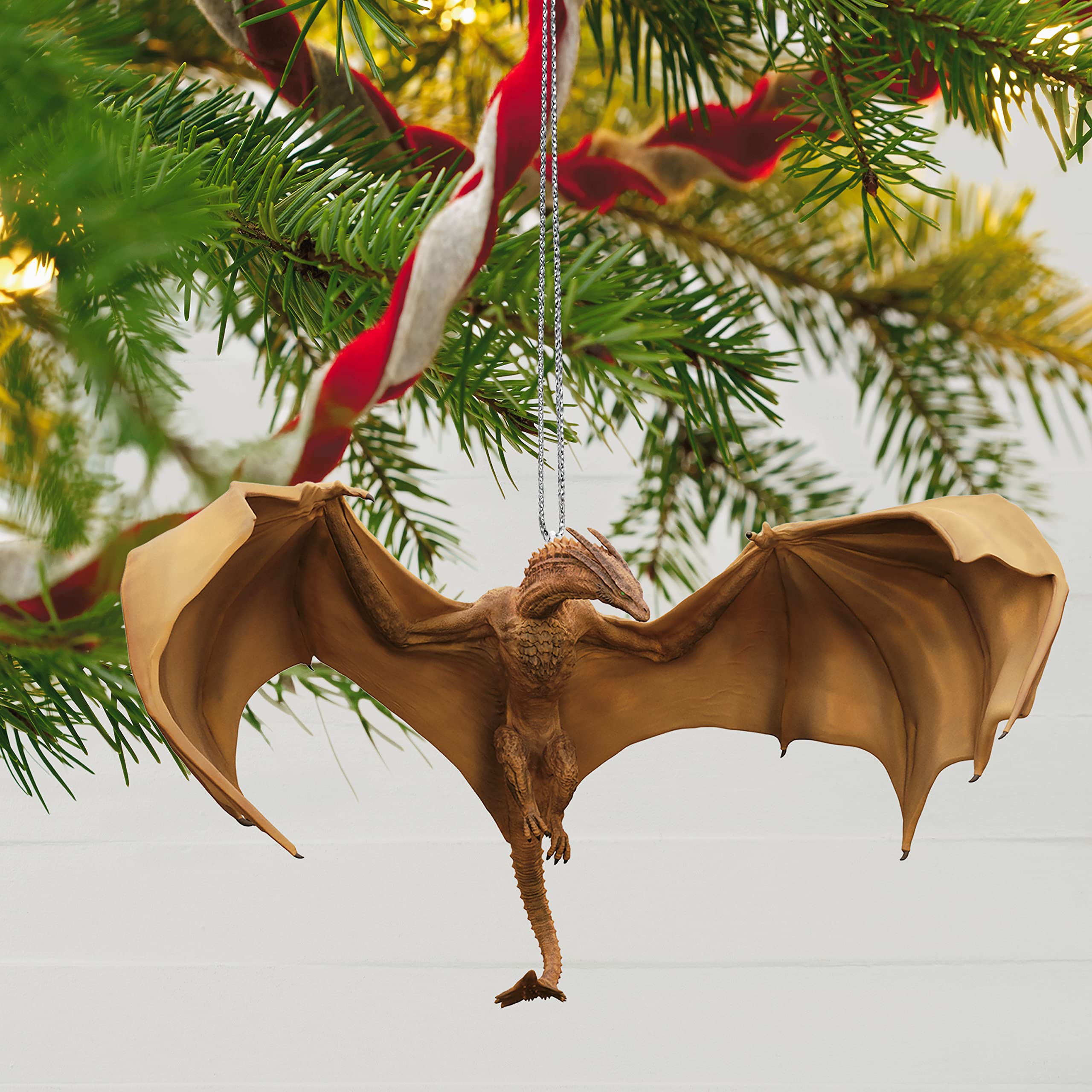 Hallmark Keepsake Syrax beside a hand to show scale and easy-hanging convenience