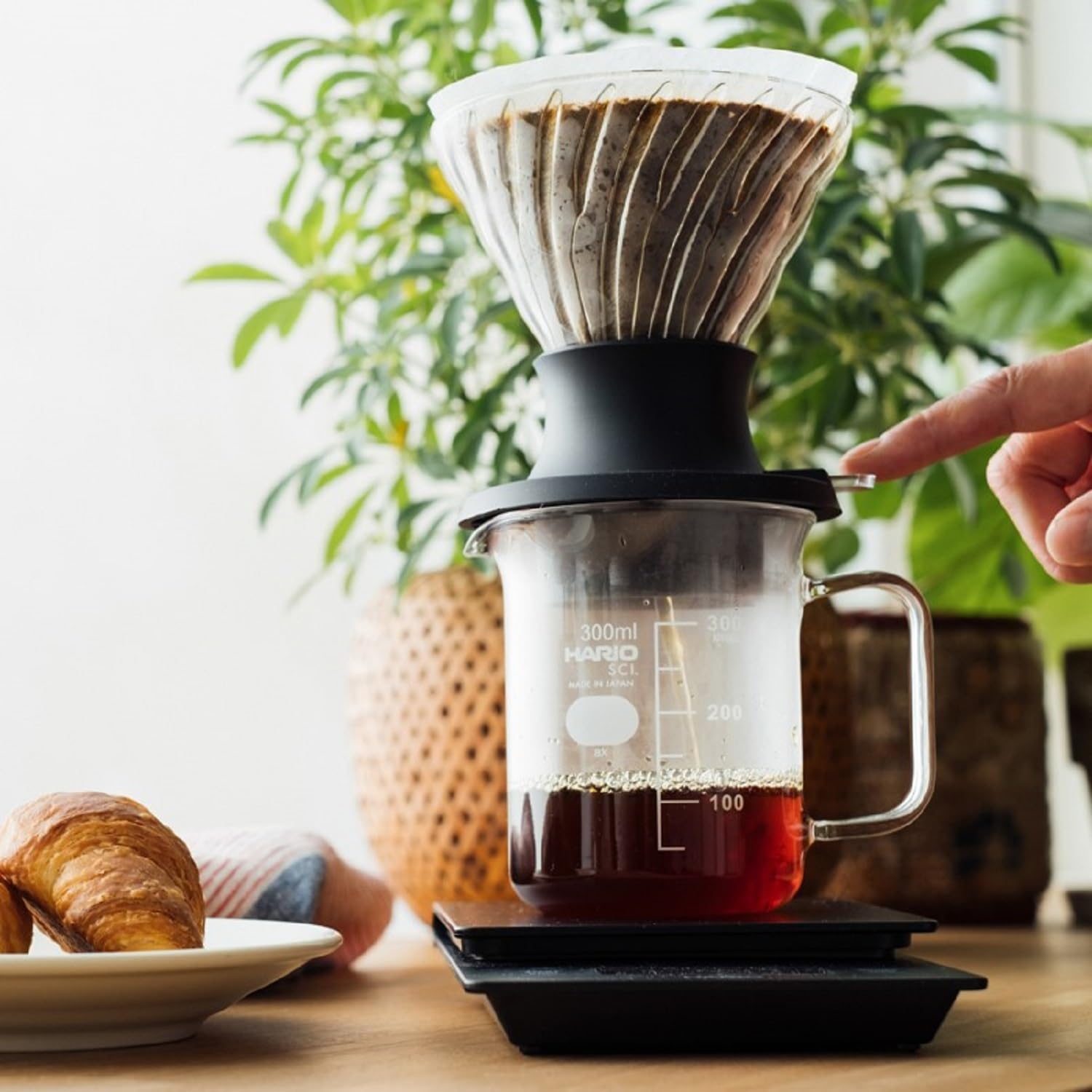 HARIO product next to a mug and scale showing compact size and portability
