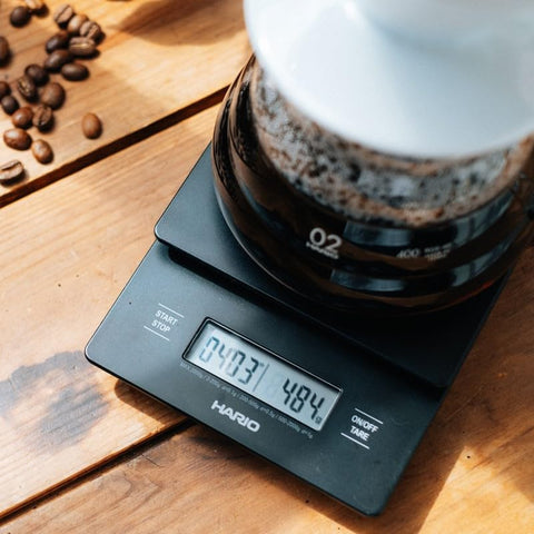 HARIO scale beside a mug to show compact size and space-saving kitchen benefit
