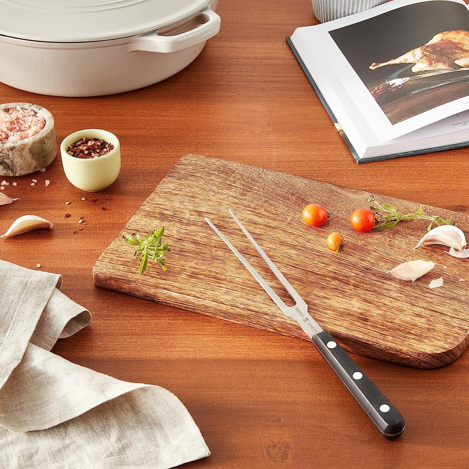HENCKELS Classic carving fork in use lifting roast to platter for safer slicing