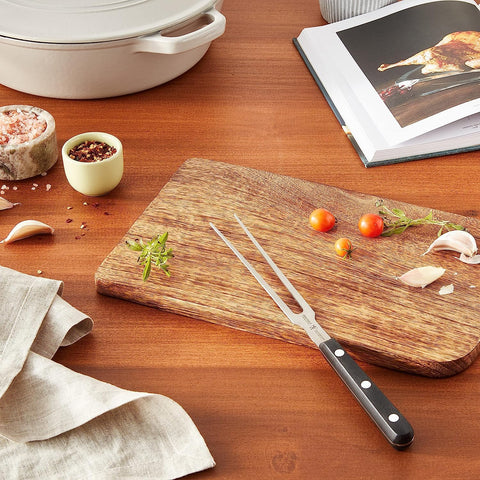 HENCKELS Classic carving fork in use lifting roast to platter for safer slicing