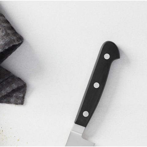 HENCKELS Classic beside a chef knife to show size and versatility benefit for mid-sized tasks