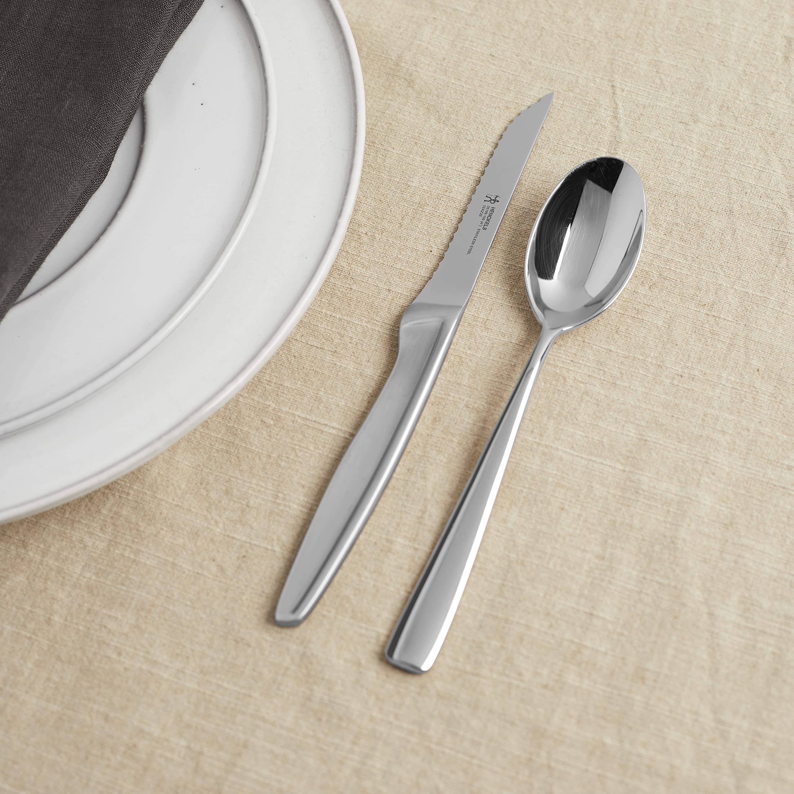HENCKELS steak knife beside a dinner fork for scale illustrating compact balanced size
