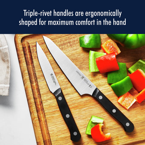 HENCKELS solution chef knife chopping herbs demonstrating precise, effortless cuts