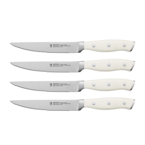 HENCKELS front view of four steak knives showing white handles and blades, elegant table presentation