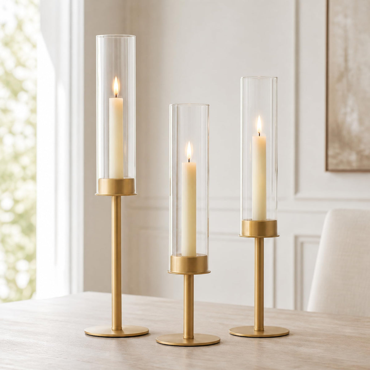 Hewory front view of three gold candlesticks showing elegant silhouette and balance