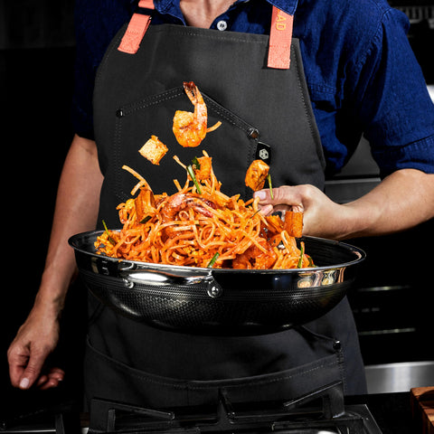 HexClad wok on kitchen range with ingredients demonstrating stovetop-to-oven versatility