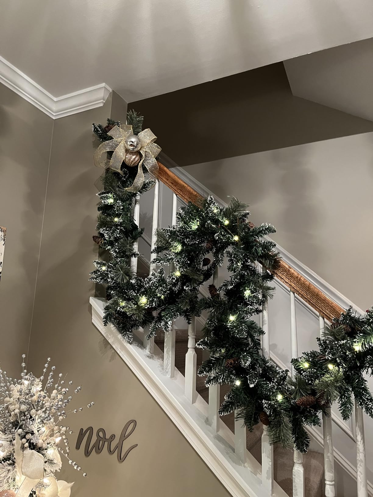 HomeKaren garland wrapped on stair banister with lights, neat installation improves entryway appeal