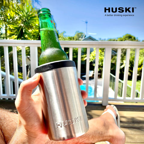 Huski beer cooler next to a hand for scale showing compact travel-friendly size