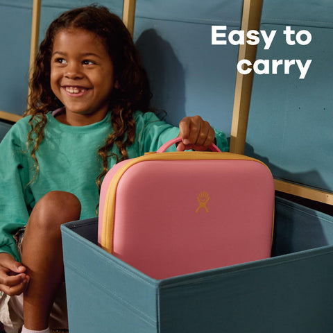 Hydro Flask lunch box next to backpack showing compact size and easy transport benefit