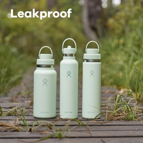 Hydro Flask next to hand and backpack for scale showing travel-friendly 32 oz capacity benefit