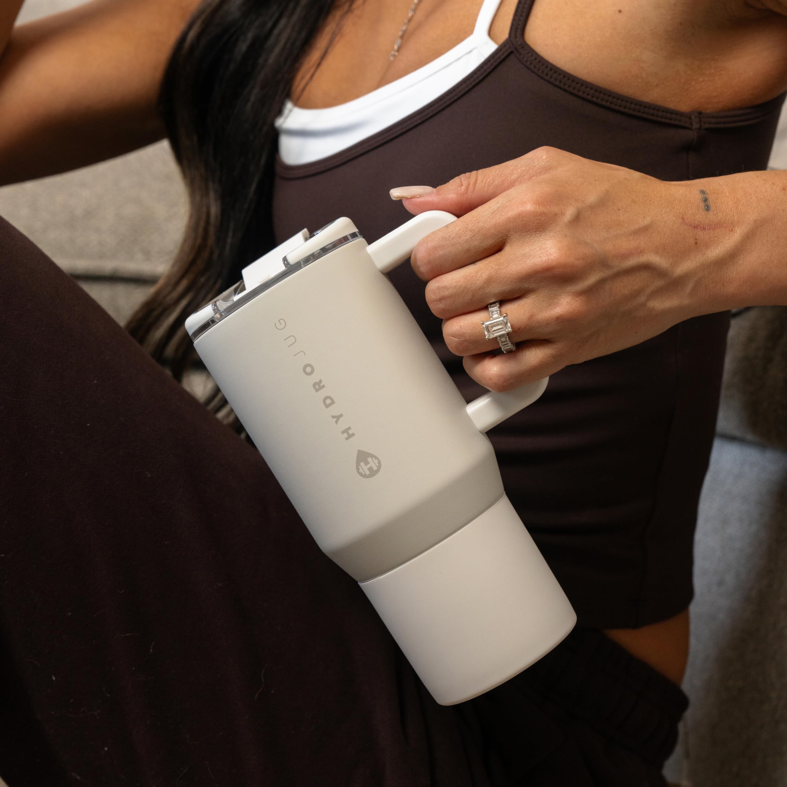HydroJug next to smartphone showing 20oz size and cup-holder fit benefit