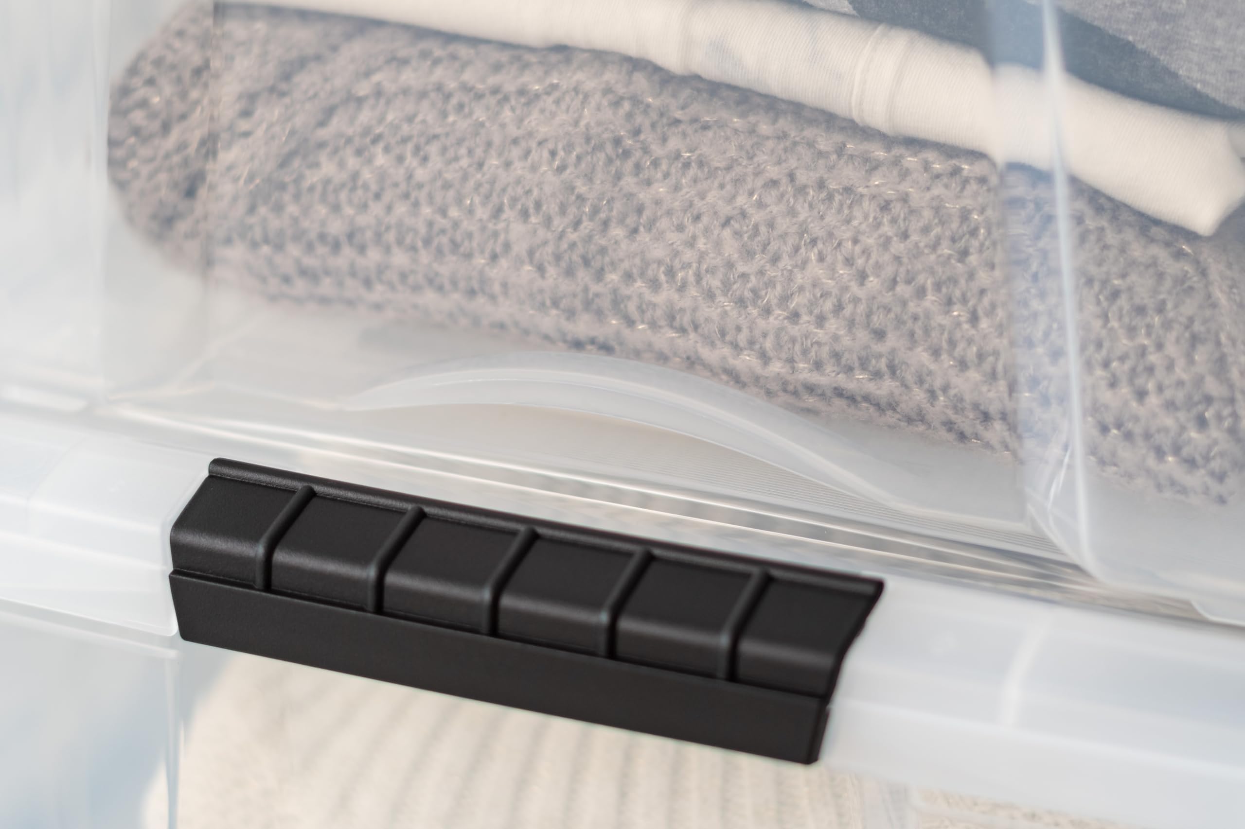 IRIS USA bin beside folded blankets illustrating true size and capacity