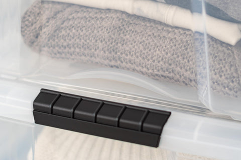 IRIS USA bin beside folded blankets illustrating true size and capacity