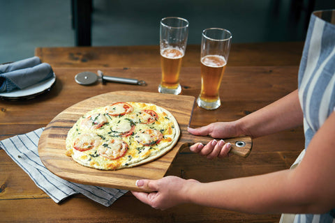 Ironwood Gourmet peel in action lifting pizza from stone for clean transfers