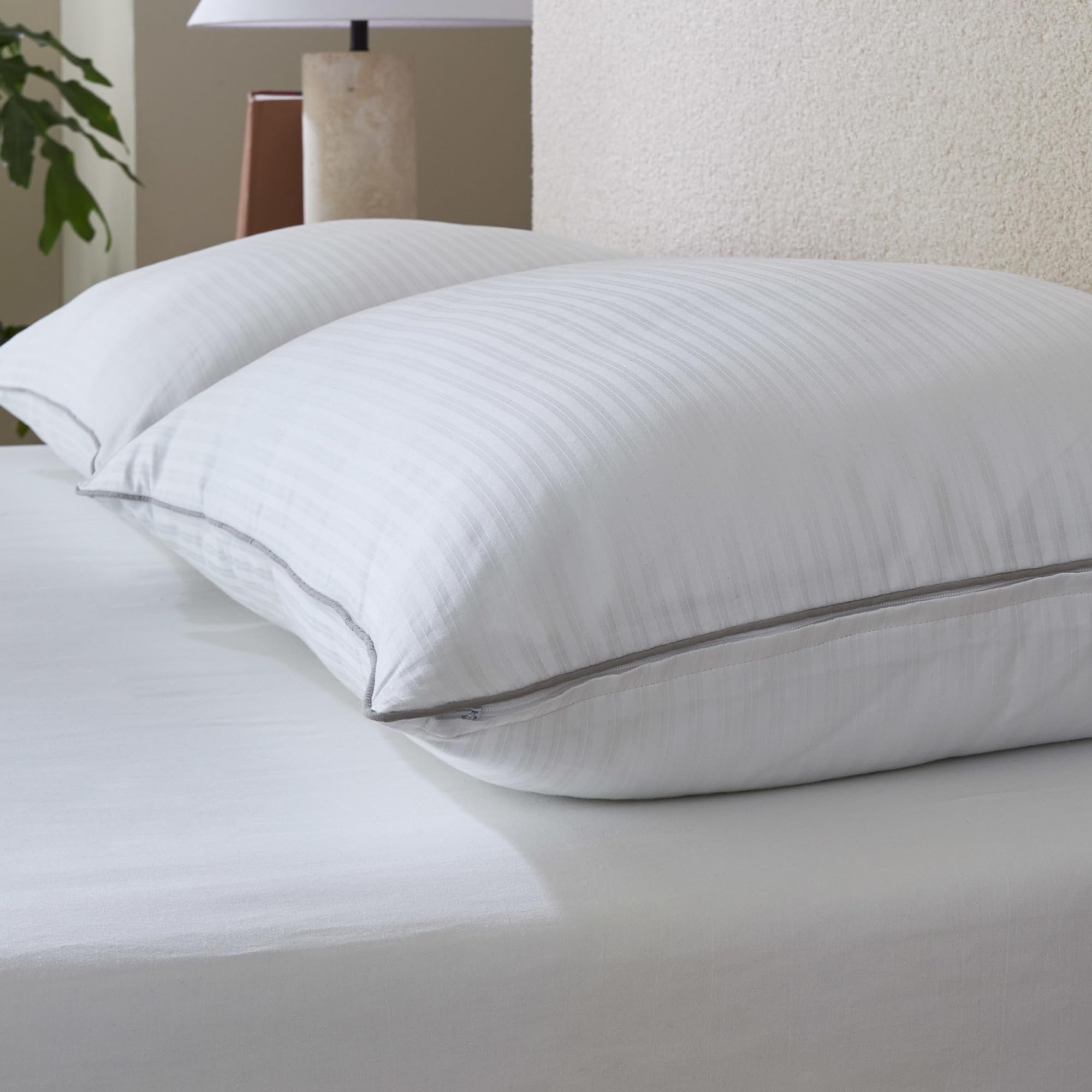 Isotonic pillow styled on made bed showing comfort for back and stomach sleepers
