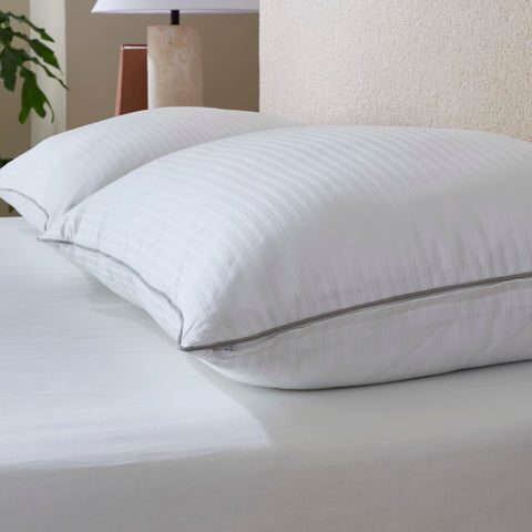 Isotonic pillow styled on made bed showing comfort for back and stomach sleepers