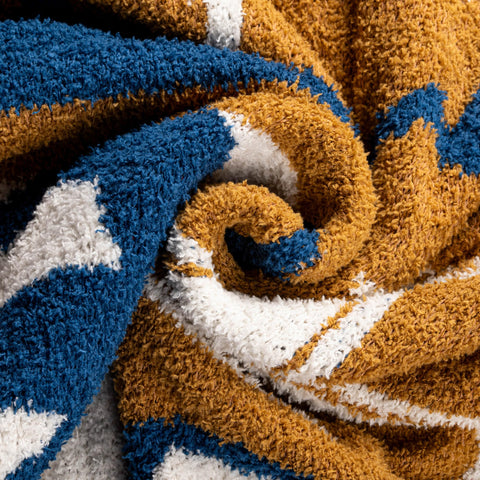 Jay Franco blanket on lap next to book showing ideal 50x60 inch size for coverage