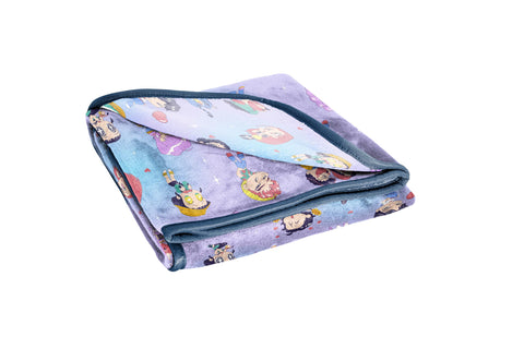 Jay Franco folded blanket next to book showing compact travel-ready size and portability benefit