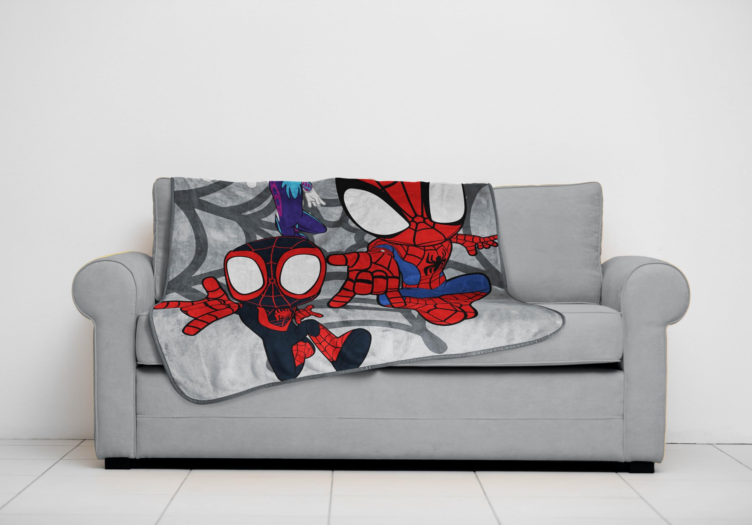Jay Franco throw draped over sofa for size comparison and everyday versatility