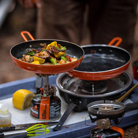 Jetboil Summit Skillet beside a water bottle showing scale and small pack footprint