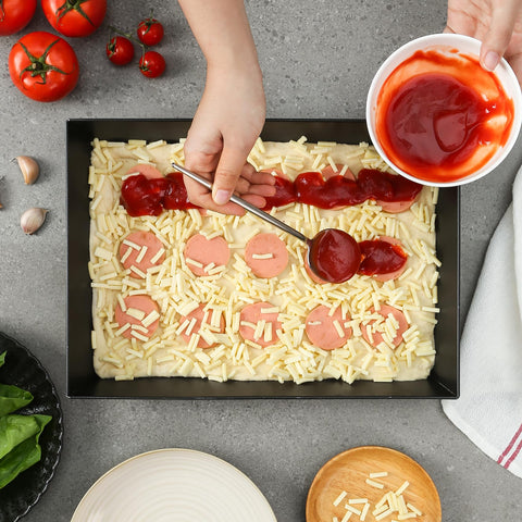 Jisculo pan with hand for scale showing compact 10x14 size convenience
